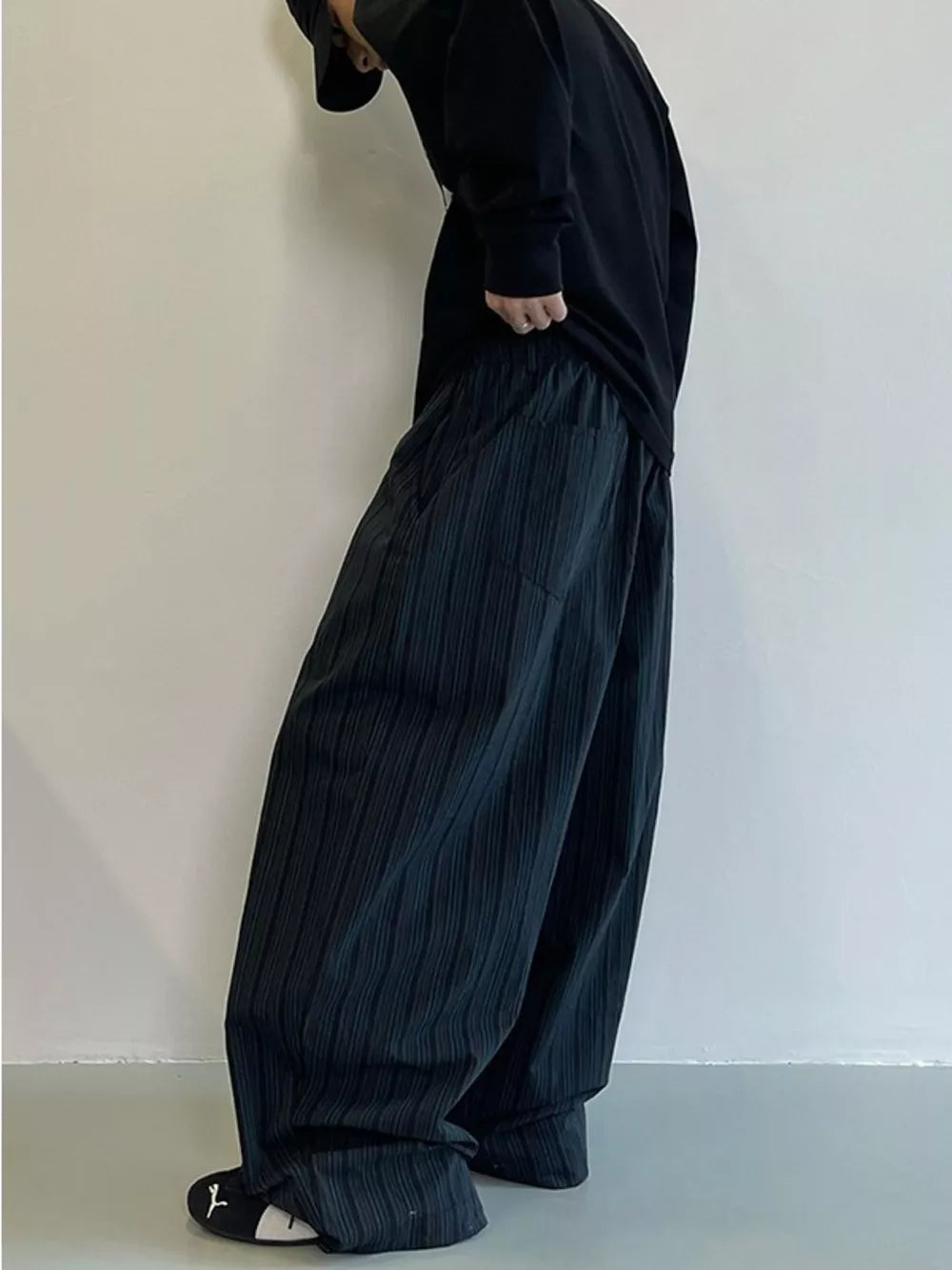 Men's dark grey striped wide-leg sweatpants with pockets, flowy fit.