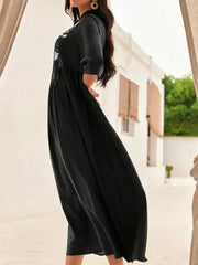 Black midi dress with embroidered floral detail, stand collar, and button-down front.