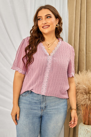 Dusty pink textured dot blouse with lace trim and short sleeves.