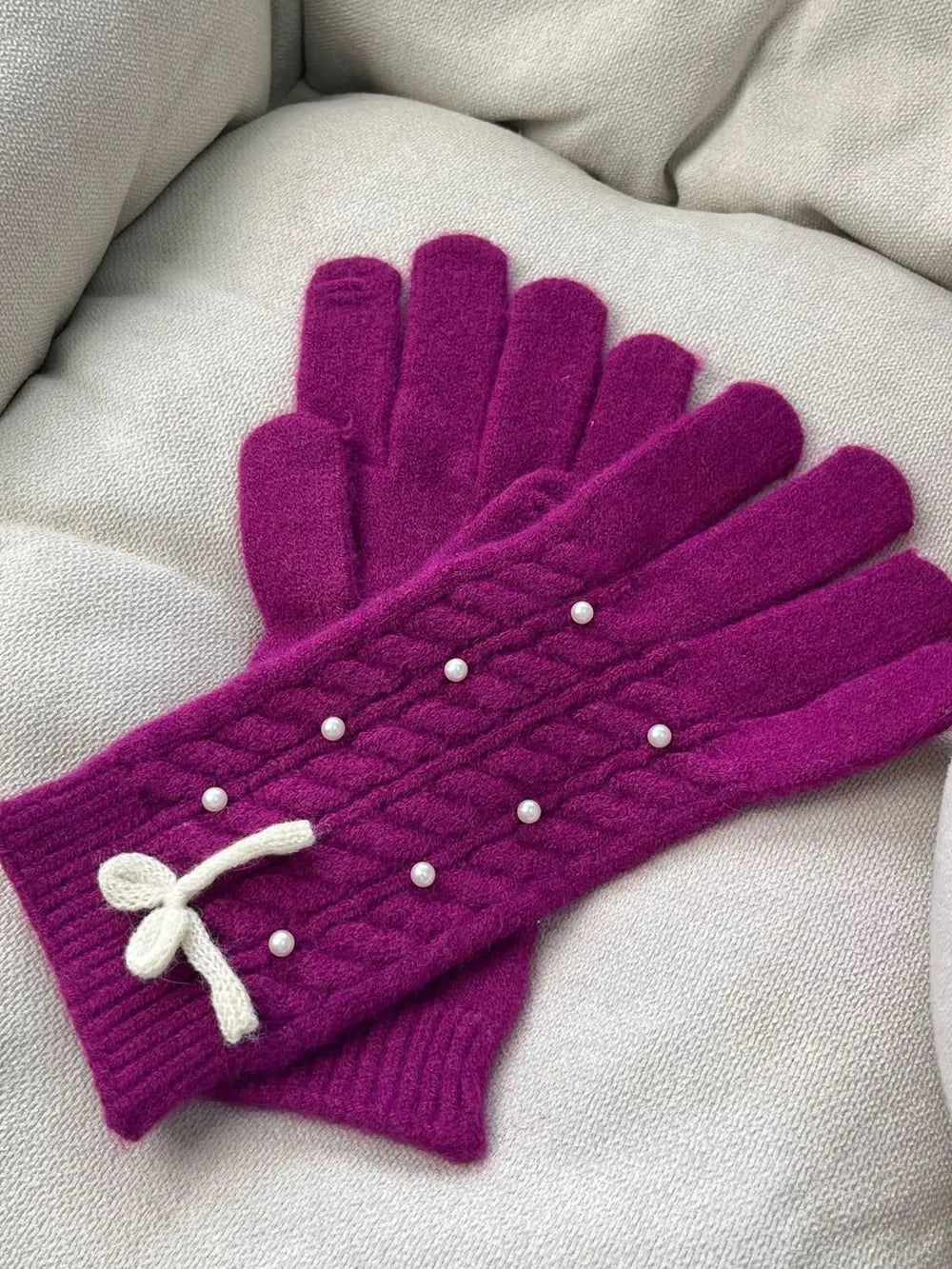Deep Purple cable knit gloves with pearl embellishments and a white bow detail.