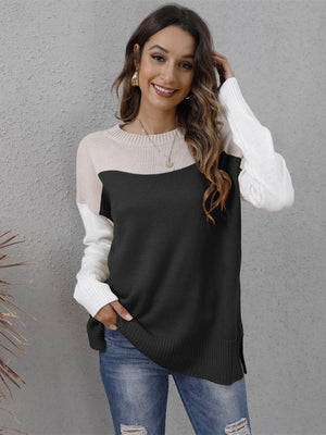 Colorblock crewneck knit sweater in black, beige, and white with side slits.