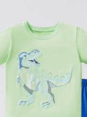Children's light green cotton tee with a textured dinosaur applique and blue shorts.