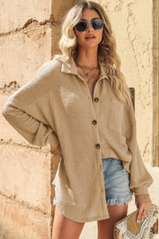 Sand waffle-knit oversized shirt jacket with button front and chest pocket, styled with denim shorts.