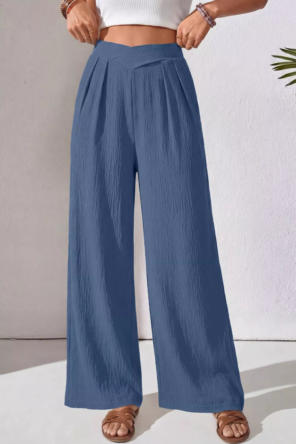 Dusty blue textured maternity pants with a crossed waist and wide legs.