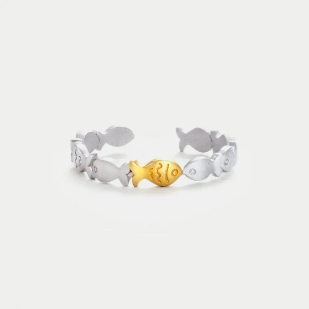 Adjustable ring with a silver band and a gold fish accent, featuring a school of fish design.