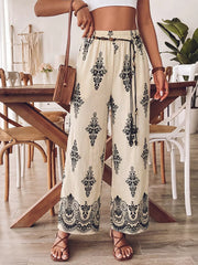 Bohemian wide leg maternity pants in beige with black boho print, featuring a drawstring waist and pockets.