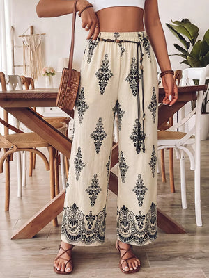Bohemian wide leg maternity pants in beige with black boho print, featuring a drawstring waist and pockets.
