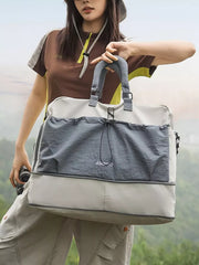 Crinkled nylon drawstring travel bag in gray and beige with top handles and a shoulder strap.