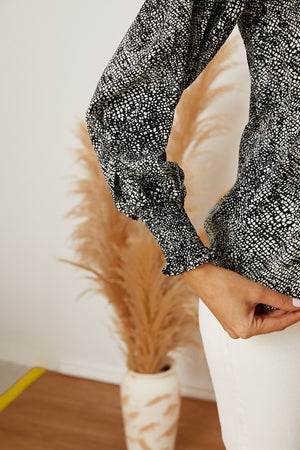 Black serpentine print blouse with gathered long sleeves and elastic cuffs.