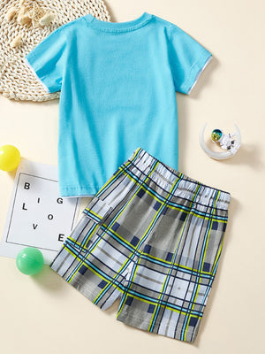 Baby boys blue cotton tee with white trim and grey plaid shorts with blue and green accents.