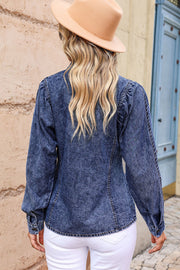 Acid wash denim shirt with puff sleeves and button cuffs, styled with white pants.