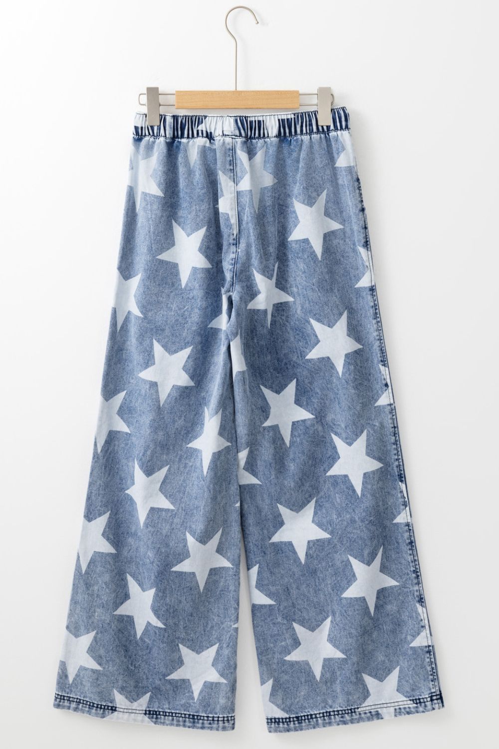 Cosmic Wash Star Print Palazzo Jeans in medium wash denim with white stars and an elastic waistband.
