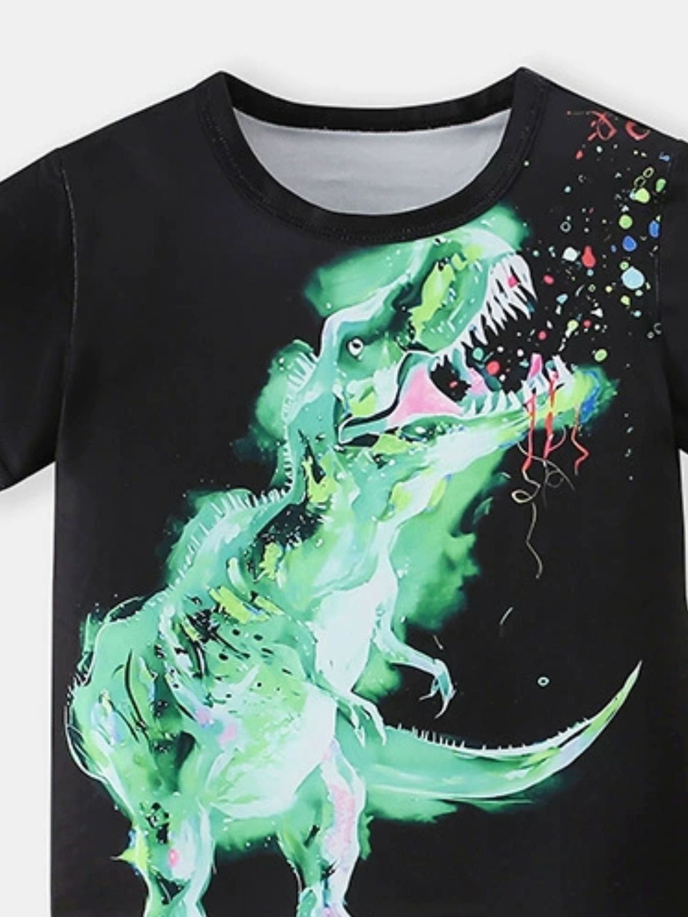 Black toddler t-shirt with a neon green dinosaur graphic and colorful splatter detail.