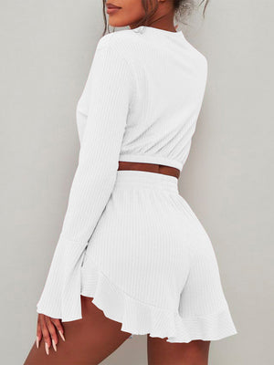 White ribbed crop set with flared sleeves and ruffled shorts.