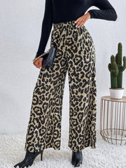 Leopard print palazzo trousers with an elastic waist, shown on a model with a black top and black boots.