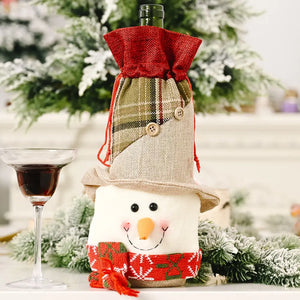 Holiday wine bottle cover with snowman face, plaid and burlap details, and red drawstring top.