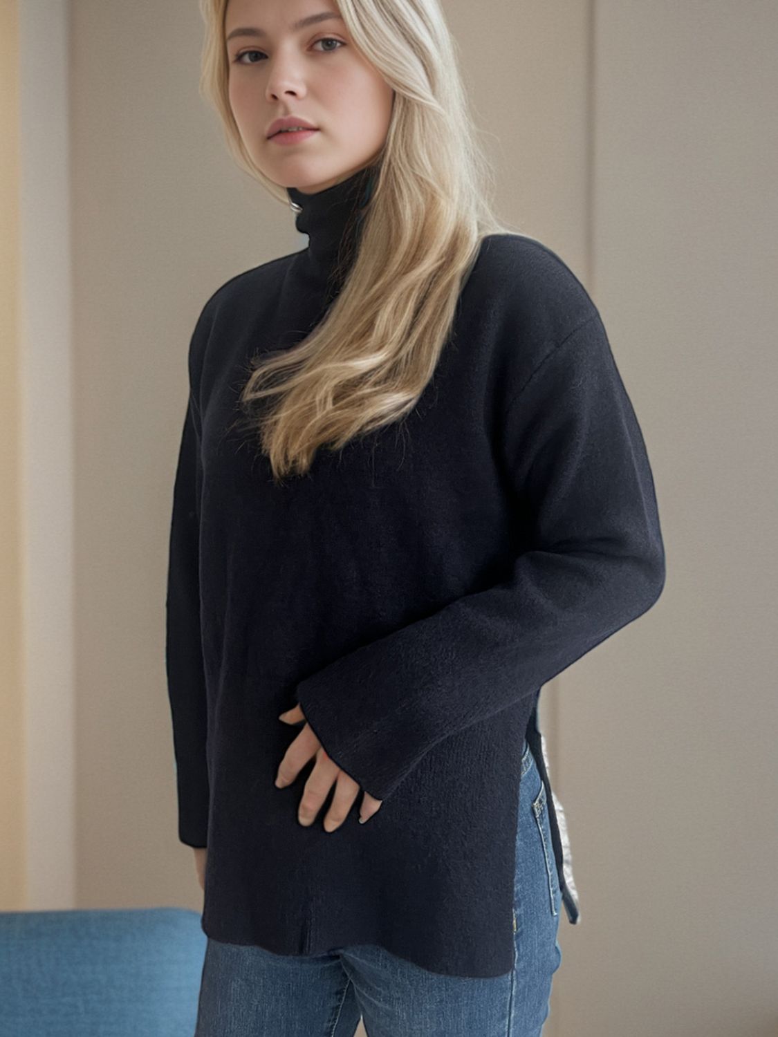 Black ribbed turtleneck sweater with slit sides and a casual fit.
