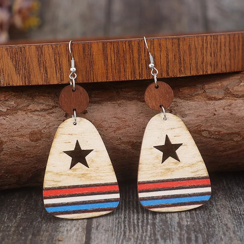 Wooden dangle earrings with star cutouts and red, white, and blue stripes.