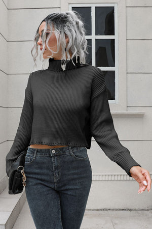 Black ribbed turtleneck sweater with scalloped hem detail