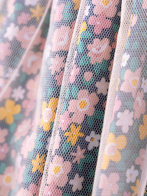 Children's floral tulle dress with pink, yellow, and white flowers on a charcoal background.