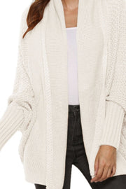 Ivory cocoon knit cardigan with shawl collar and batwing sleeves.