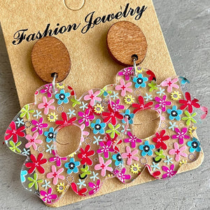 Floral acrylic bloom earrings with wood tops, featuring a colorful floral pattern.
