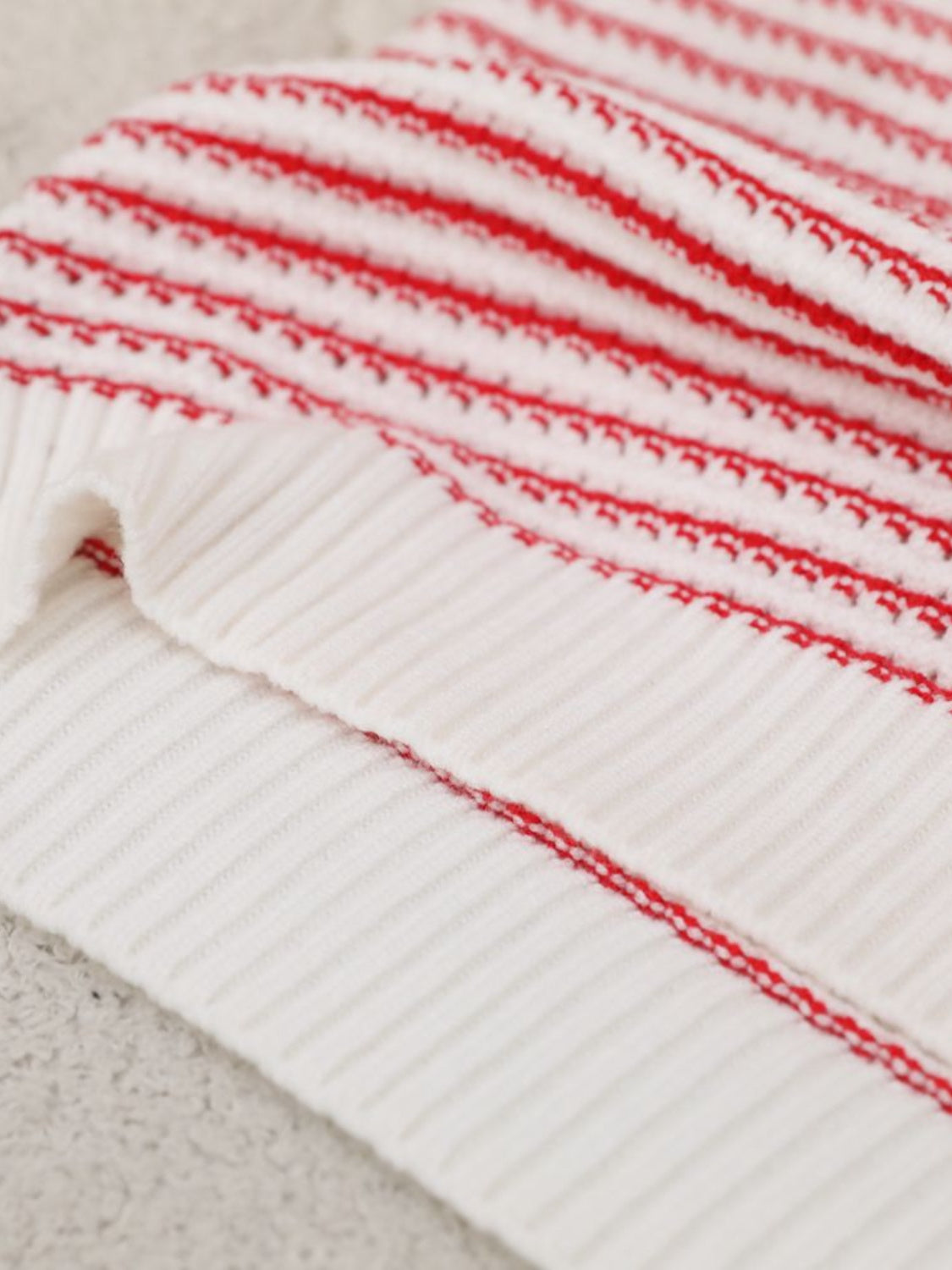White knit shell top with horizontal red stripes and ribbed texture.