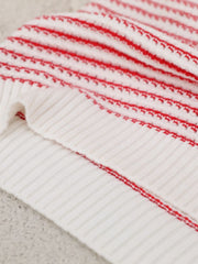 White knit shell top with horizontal red stripes and ribbed texture.
