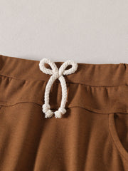 Light brown baby set shorts with drawstring waist and pocket detail.