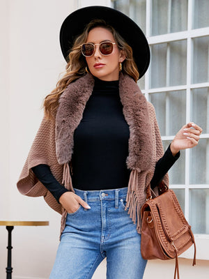 Textured knit poncho with faux fur collar and fringe detail in a taupe color.
