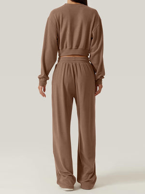 Brown knit loungewear set with cropped sweatshirt and wide-leg pants.