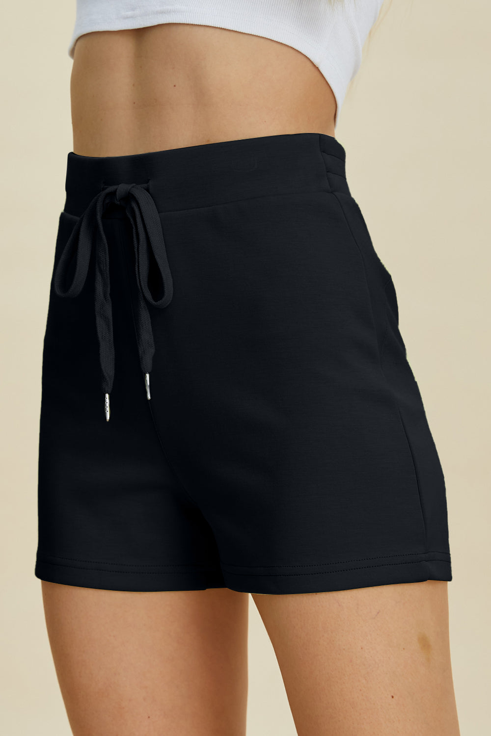 Black scuba drawstring sport shorts with a textured waistband and silver-tipped ties.
