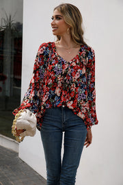 Red floral print blouse with gathered yoke and balloon sleeves.