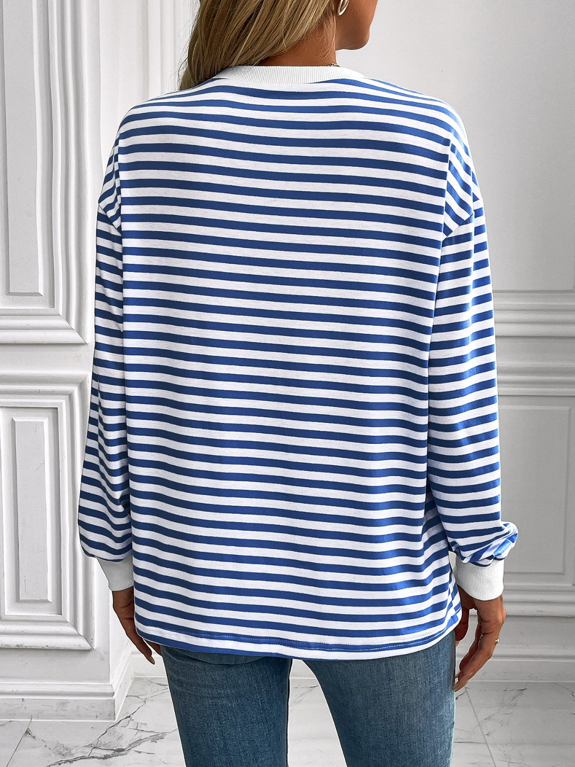 Crewneck sweatshirt with horizontal royal blue and white stripes, long sleeves, and white cuffs.