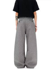 Men's grey wide-leg pleated sweatpants with a relaxed fit and button-tab back pockets.