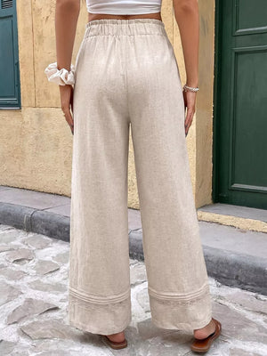 Beige wide-leg maternity pants with drawstring waist and lace trim detail.
