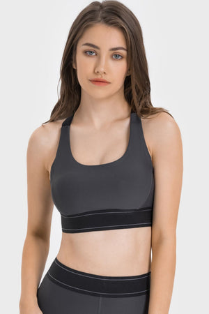 Gray performance sports bra with crossback straps and a wide black band.
