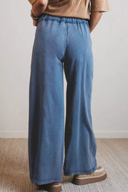 Blue denim maternity jeans with drawstring waist and wide legs.
