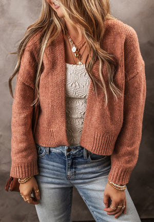 Open-front cropped knit cardigan in burnt coral acrylic with ribbed cuffs and hem.