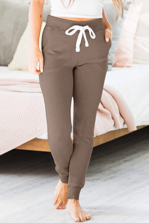 Slim-fit mocha joggers with white drawstring and cuffed ankles.