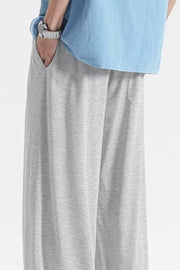 Light gray sweatpants with pockets and drawstring detail.