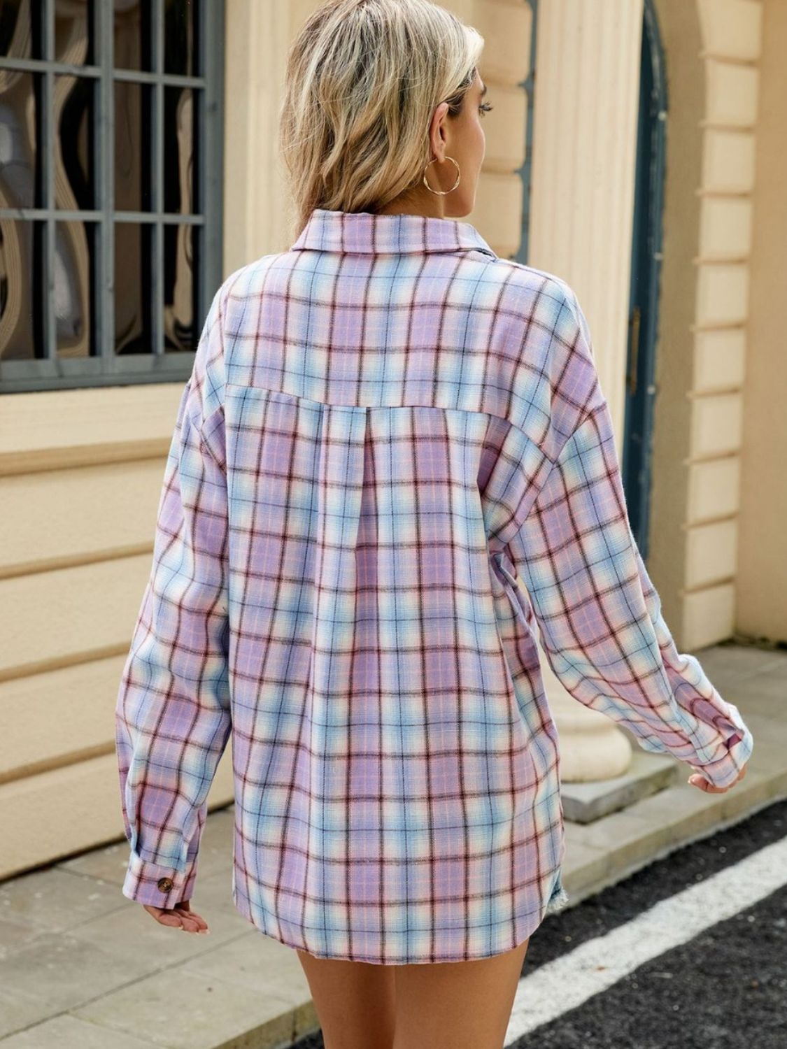 Long sleeve collared plaid shirt in pastel purple, blue, and white with button cuffs.