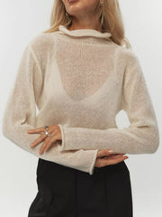 Sheer mock neck knit sweater in apricot with a ruffled neckline and long sleeves.