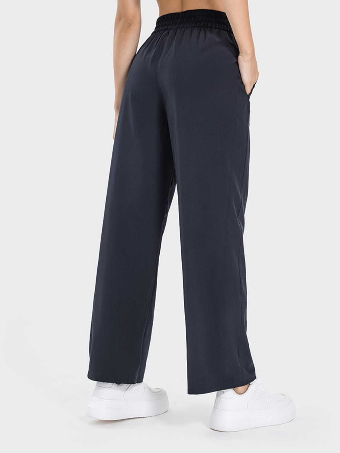 Charcoal relaxed drape drawstring palazzo pants with pockets, styled with white sneakers.