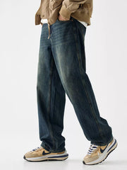 Loose fit blue denim jeans with vintage wash and visible stitching detail.