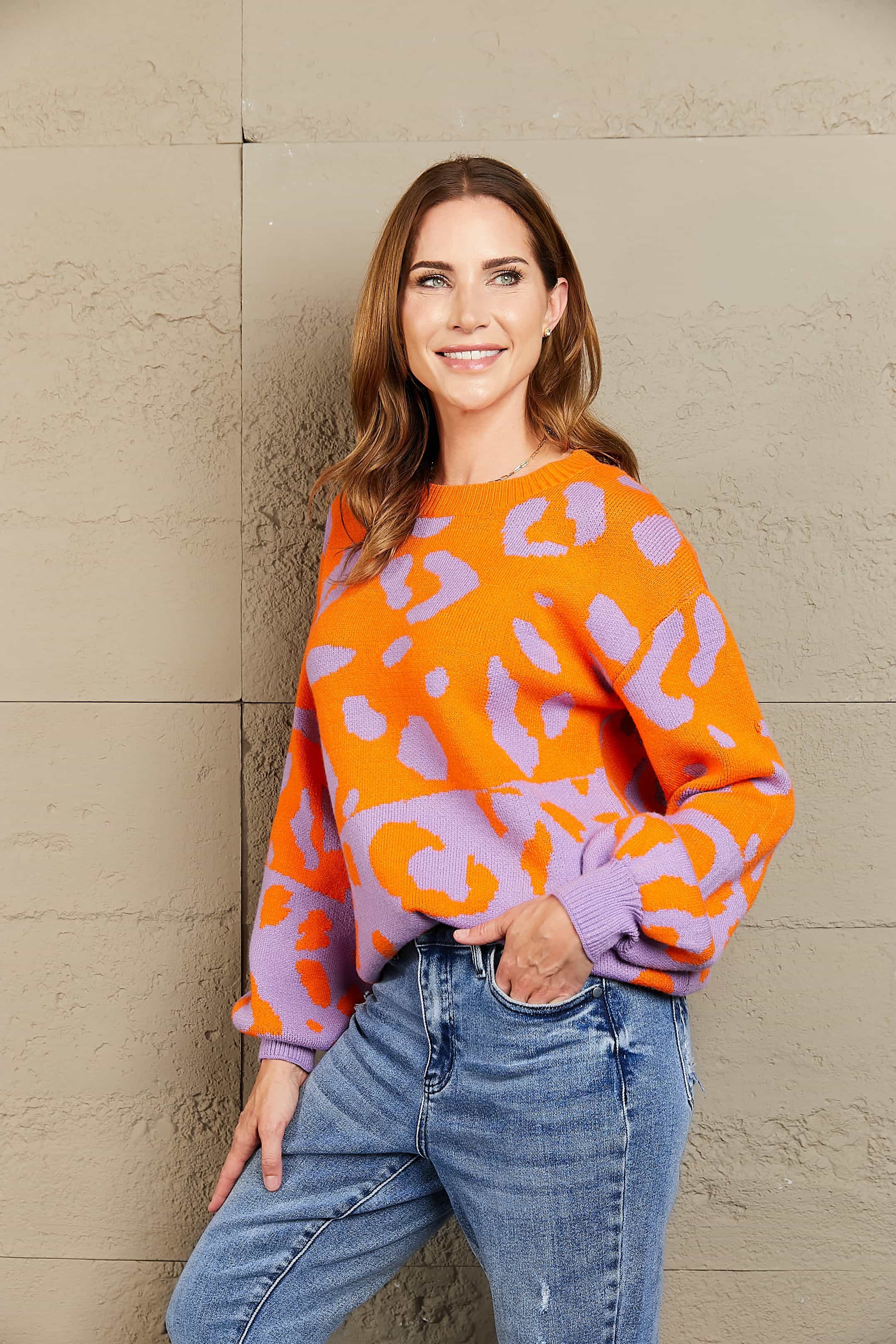 Colorblock leopard knit sweater with balloon sleeves in orange and purple.