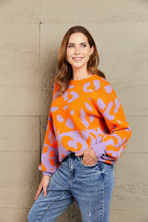 Colorblock leopard knit sweater with balloon sleeves in orange and purple.