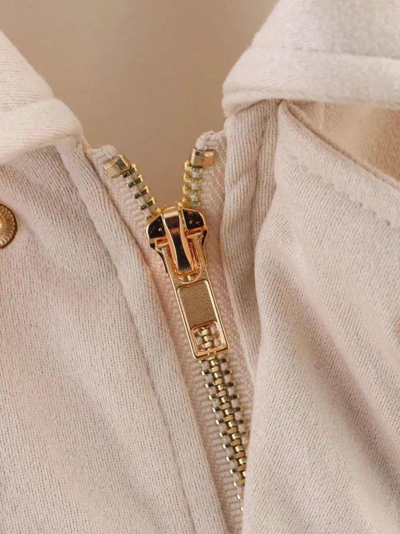 Oversized zip-up jacket in off-white with a gold zipper detail.