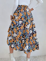 Tiered midi skirt with a black floral print, elastic waist, and flowy hem.