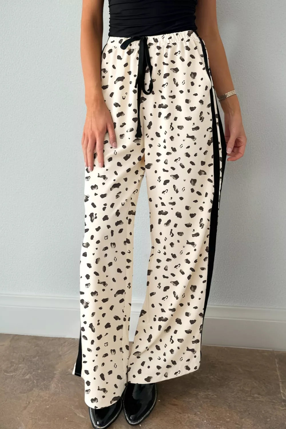 Maternity leggings in cream with black abstract leopard print, drawstring waist, and side stripe detail.
